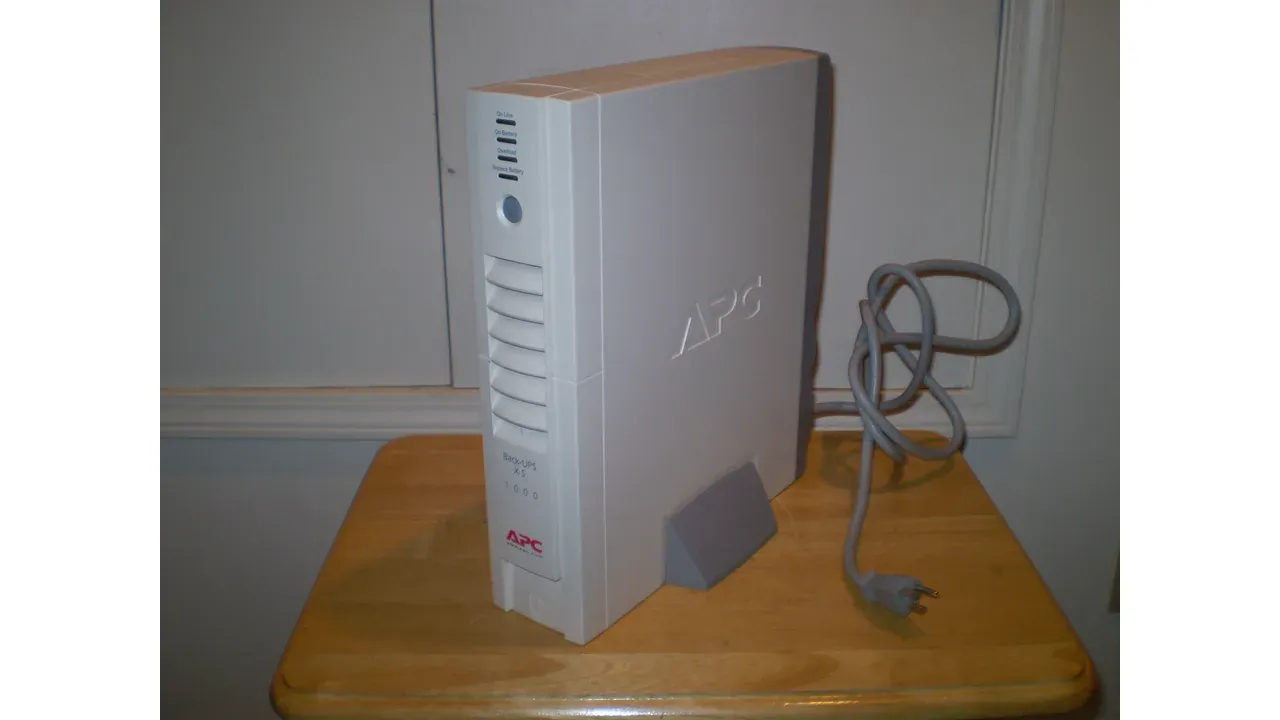 An APC Back-UPS XS 1000, model BX1000, photographed 26 March 2020. The lead image is a 1280 by 720 WebP that fits the full Commons photograph into a 16:9 frame. Photo by Rjluna2, CC BY-SA 4.0, via Wikimedia Commons.