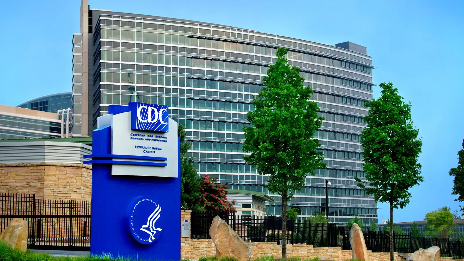 Exterior of the Centers for Disease Control and Prevention’s Roybal campus in Atlanta, a glass-and-concrete federal complex with a circular drive and trees, photographed 23 June 2013. Photo by James Gathany, Centers for Disease Control and Prevention, public domain.