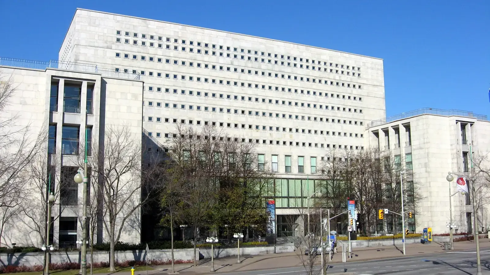Headquarters of Library and Archives Canada on Wellington Street in Ottawa, a glass-and-stone federal building with a grid of windows, photographed 10 November 2007. Photo by Padraic Ryan, CC BY-SA 3.0, via Wikimedia Commons.