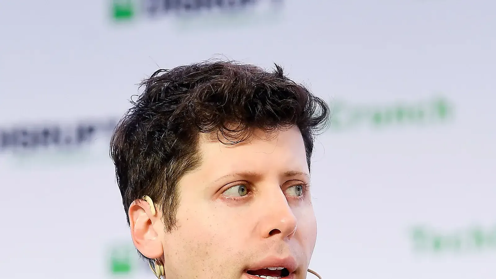 Sam Altman speaking on stage at TechCrunch Disrupt in San Francisco on 3 October 2019, in a black sweater, with a dark auditorium behind him. Photo by Steve Jennings / Getty Images for TechCrunch, CC BY 2.0, via Wikimedia Commons.