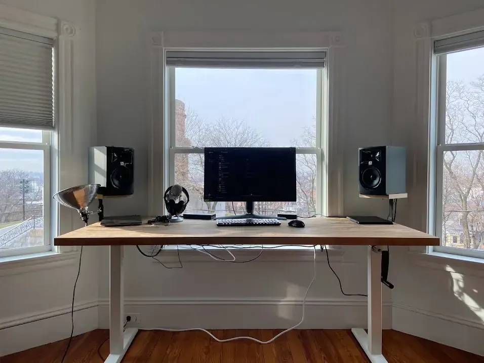 Adjustable height desk with monitor and speakers, photographed 27 January 2022. Photo by Nelsnelson, CC BY-SA 4.0, via Wikimedia Commons.